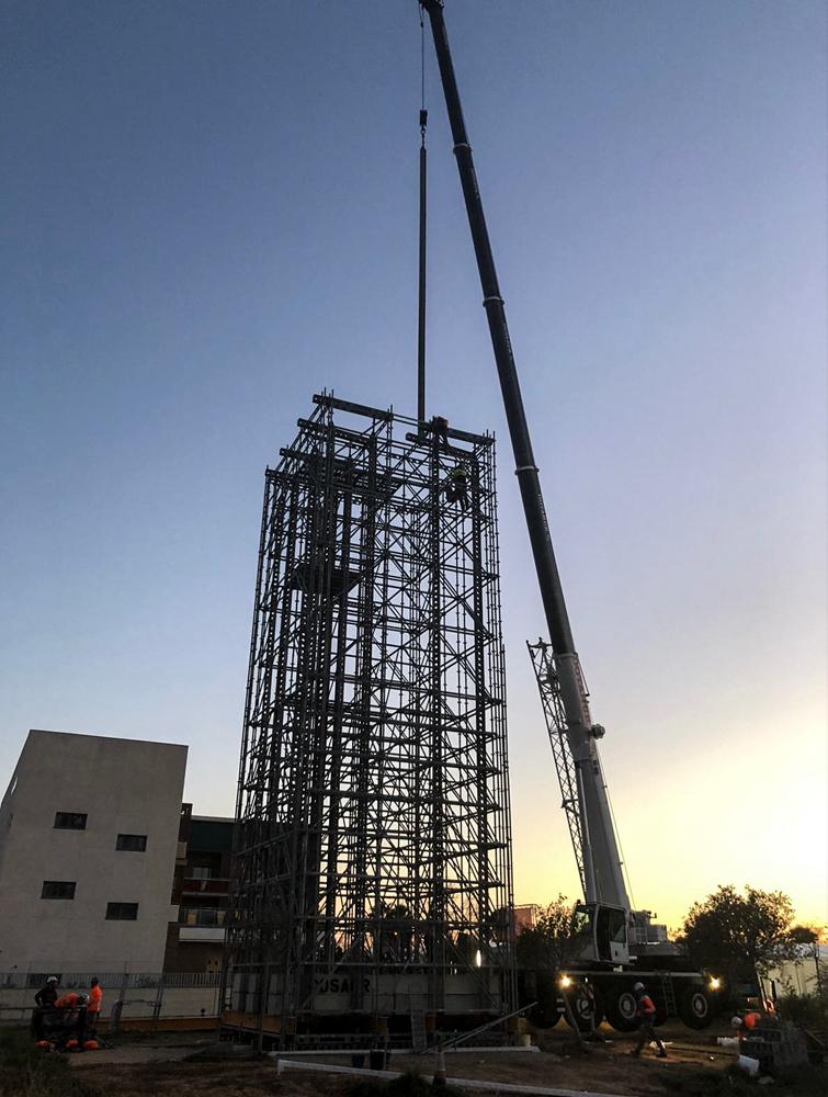 Vista completa del andamio de instalación de las torres con grúa móvil a la derecha.