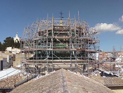 Cúpula de iglesia cubierta por andamio, vista desde un tejado enfrente
