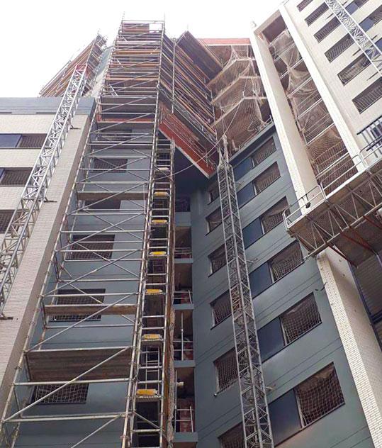Vista en contrapicado de edificio con andamio de creamallera
